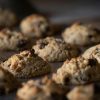 A close-up shot of freshly baked chocolate chip cookies on a tray, showcasing their texture and indulgence.